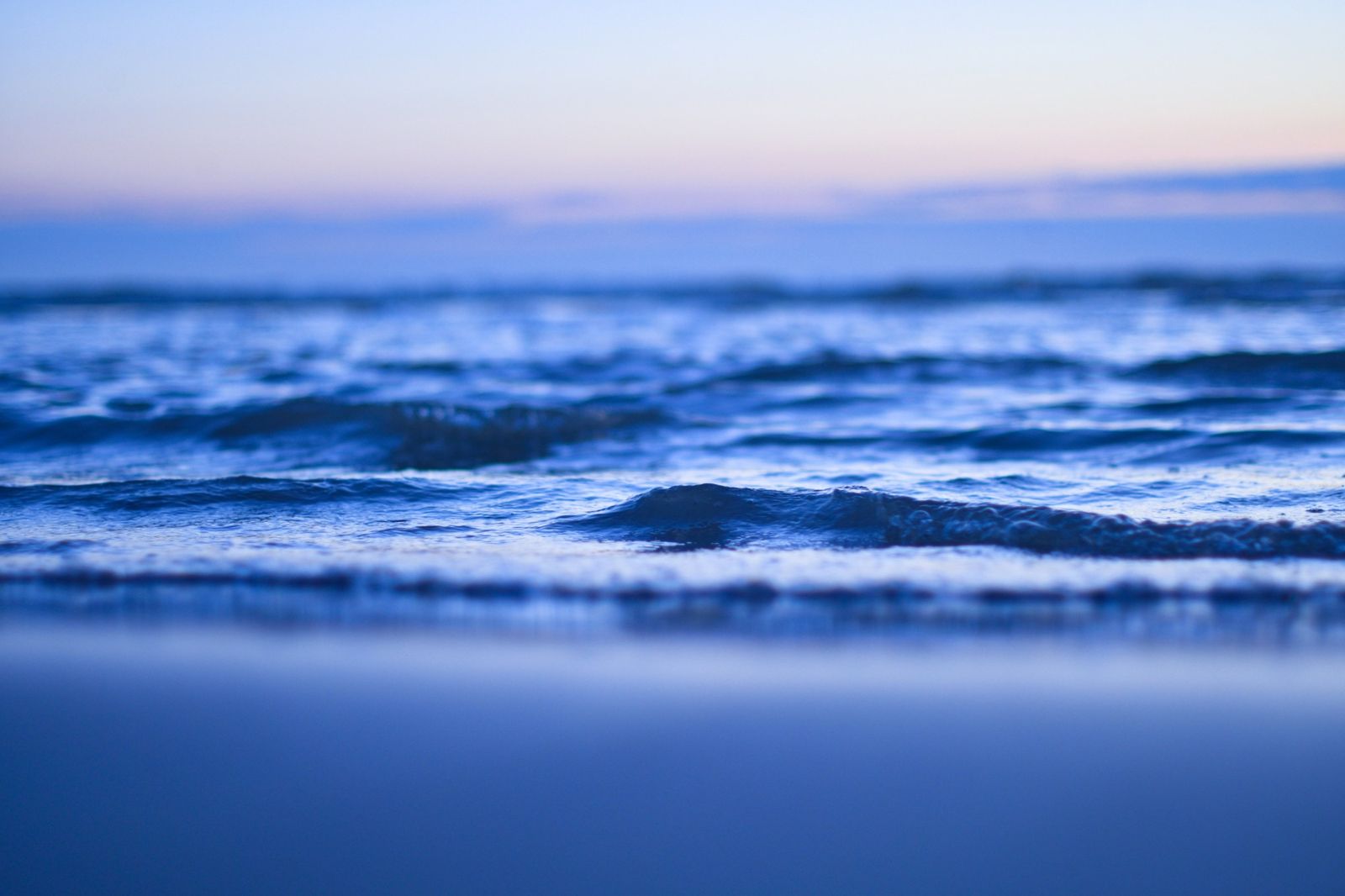 Wasser in Bewegung Ruhige blaue Wasseroberfläche mit sanften Wellen in der Dämmerung